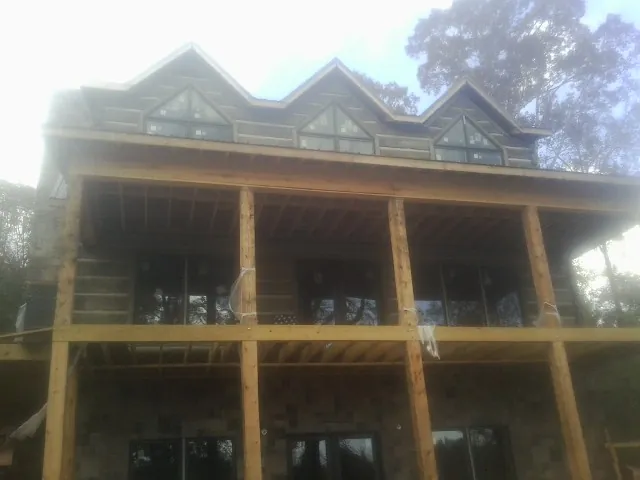 Dormers and porch framing on a large log home under construction — Roof Coating work by our crew in Menifee